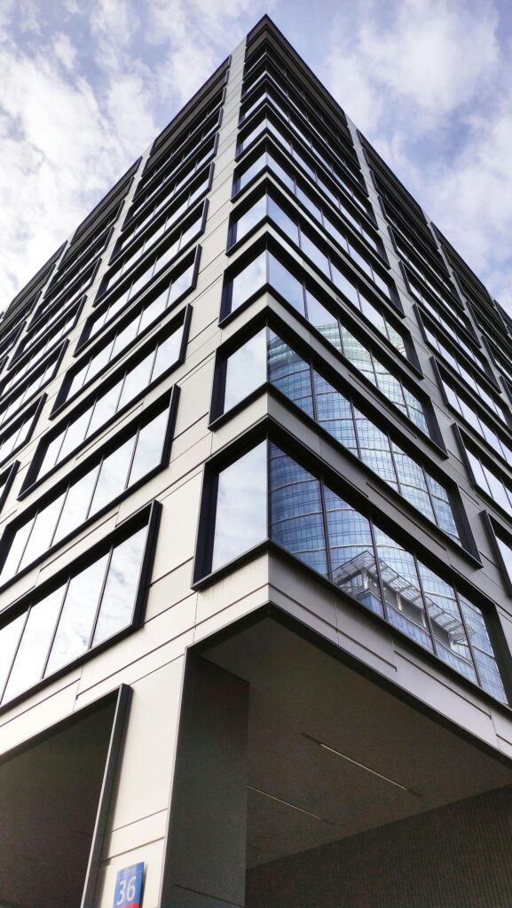 Low-angle view of a modern skyscraper in Warsaw, reflecting urban architecture.